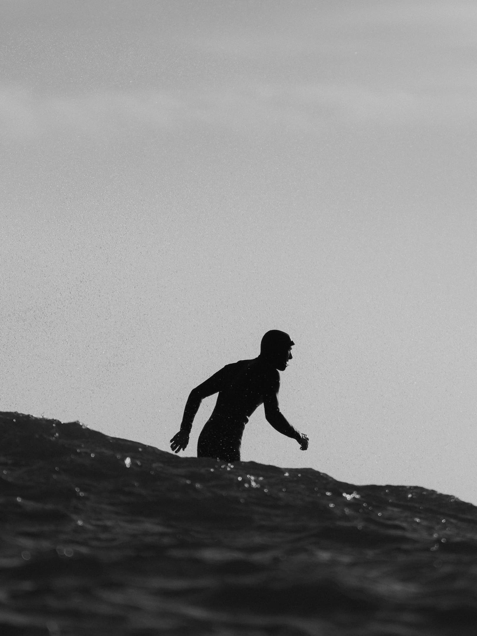 Silhouette noir et blanc d'un surfeur dans l'ocean