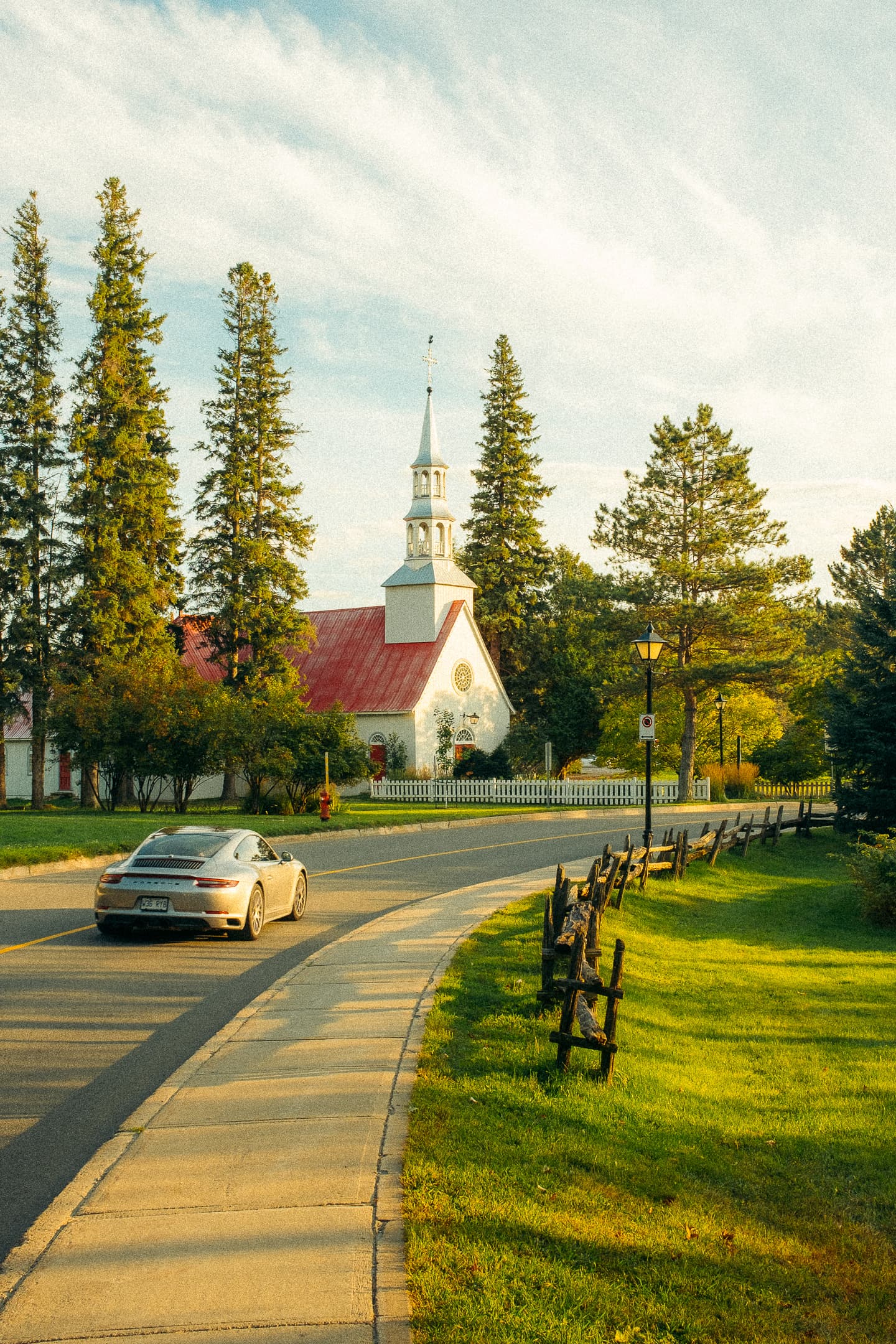 Église québécoise et Porsche 911 sur une route de campagne